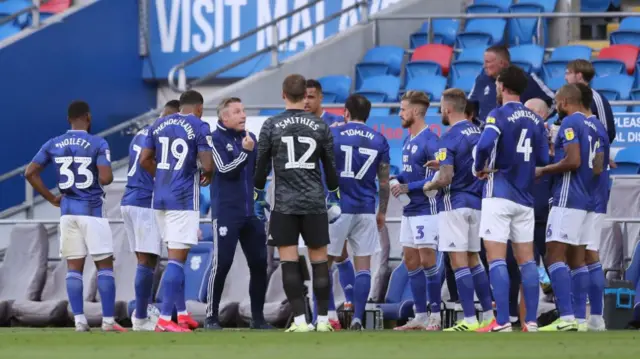 Neil Harris manager of Cardiff City talks to his players during the drinks break