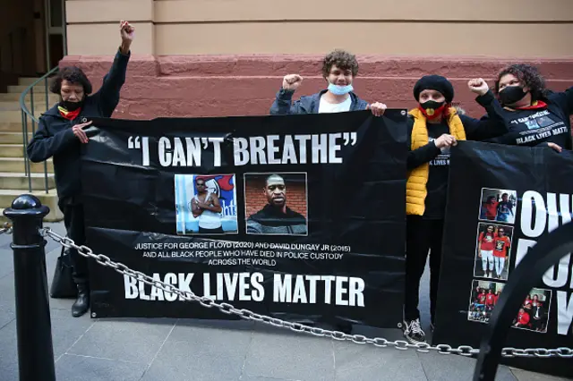 Leetona Dungay and her supporters hold a protest banner