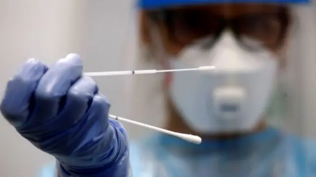 A doctor holds a test stick