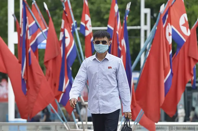 A man walks in Pyongyang wearing a face mask