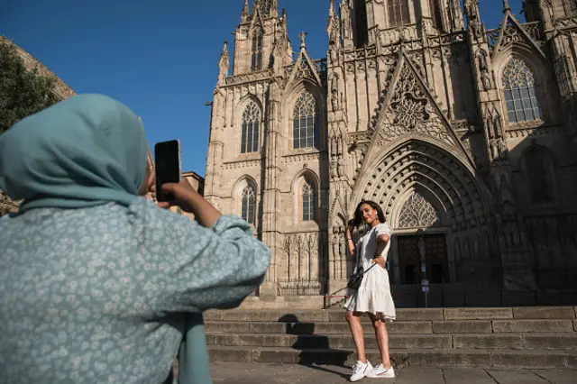 People pose for photos in front of the Barcelona Cathedral