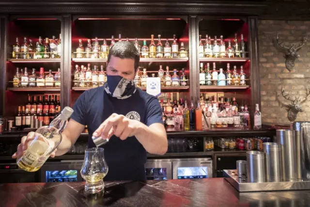 A barman serves a whisky at The Piper"s Rest pub in Edinburgh