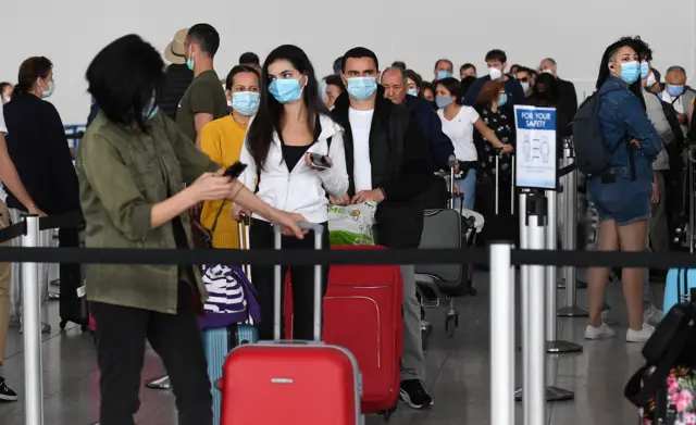 Travellers queuing at Stansted Airport