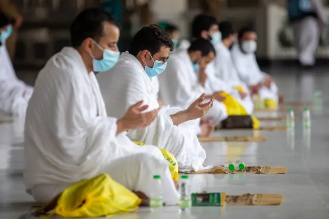 Muslim pilgrims wearing protective face masks pray around the Kaaba at the Grand mosque during the annual Haj pilgrimage