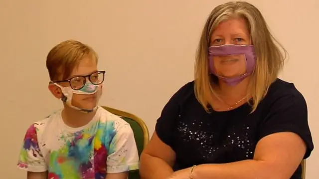 Gregor Craig and his mum Martine wearing the face coverings made by volunteers