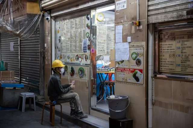 A worker waits for his take away lunch in Hong Kong