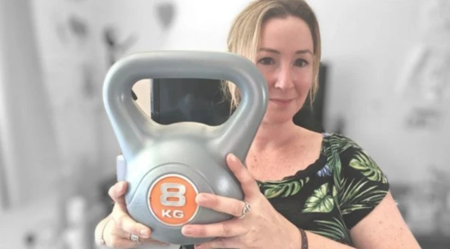 Zoe Kleinman, BBC tech reporter, holding a kettlebell