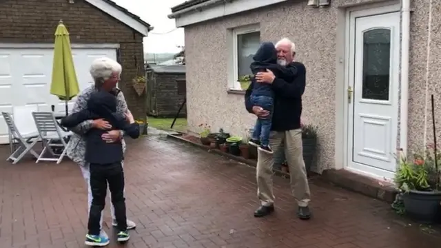 Noah and Isaac hugging their grandparents