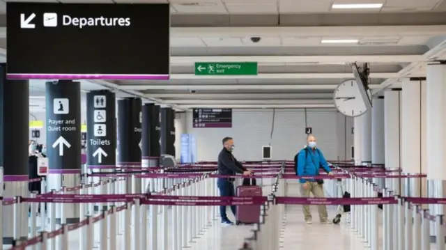 Two passengers wait to check in at Edinburgh Airport