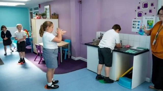 Pupils take hygiene measures in a classroom