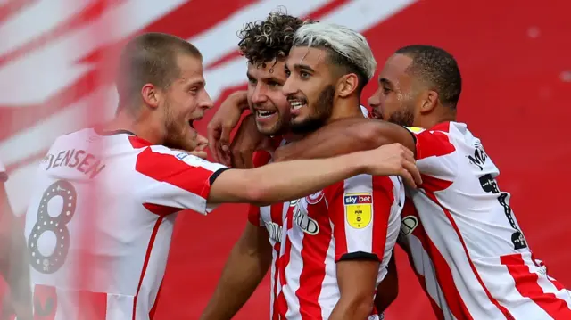 Brentford players celebrate a goal against Swansea