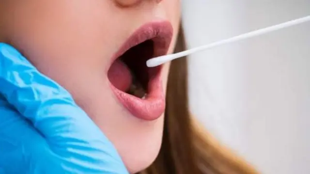 A woman receiving a mouth swab