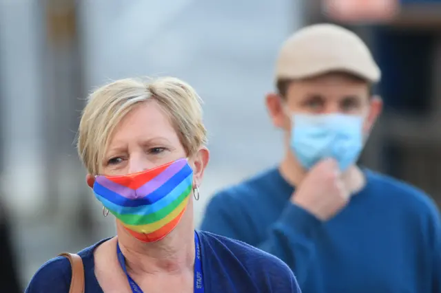 A woman wearing a face mask walks through the centre of Bradford