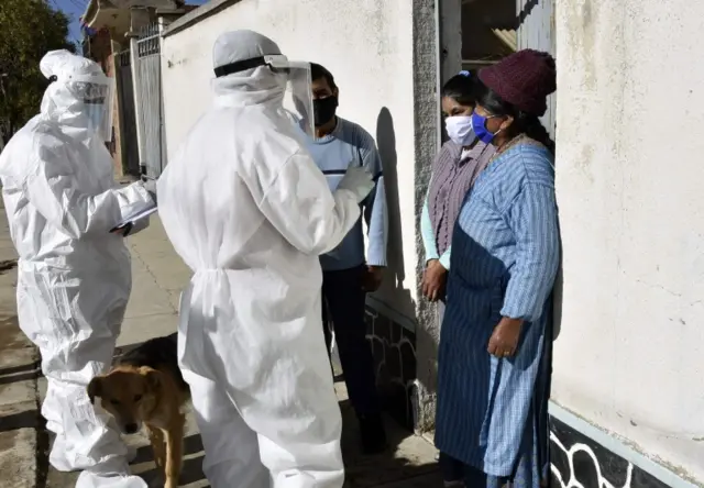 Health workers carry out a door-to-door visit to check for possible cases of COVID-19, within the coronavirus pandemic, on July 4, 2020, in El Alto, Bolivia.