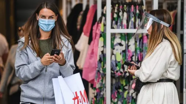 Woman leaving shop in mask