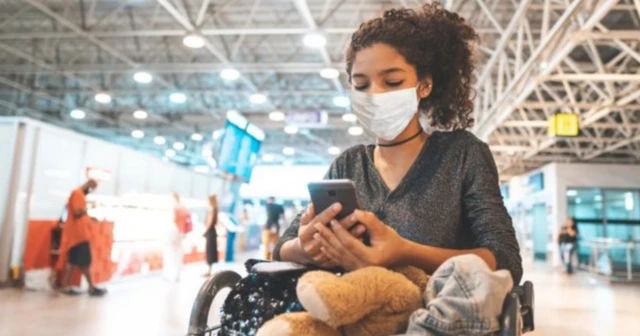 A girl looking at her phone in an airport. File photo