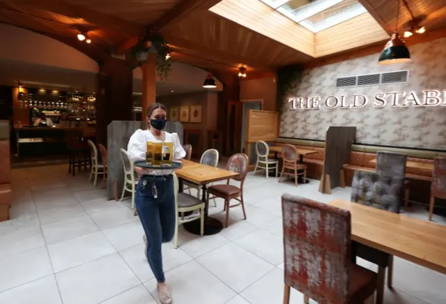 A member of staff delivers pints wearing a face mask at a pub in Liverpool