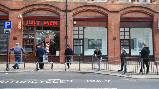 Men queue outside Just Men barbers in Leeds, as coronavirus lockdown restrictions are eased across England.