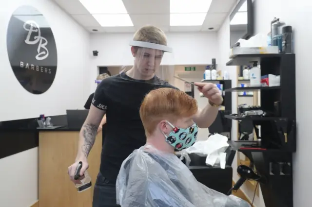 A customer has a haircut at a barbers in Ashford, Kent