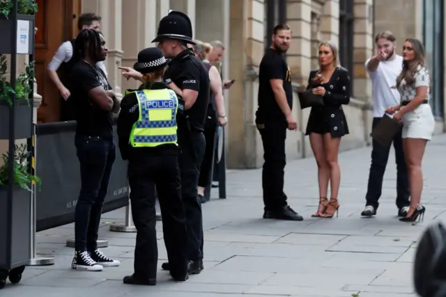 Police talk to customers outside a bar in Newcastle