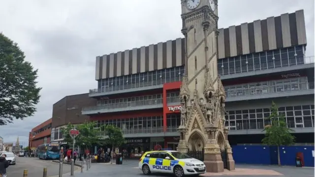 Police patrol by a clock tower