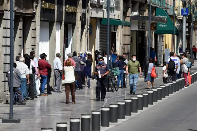 People wait to enter a store in Mexico City on 1 July 2020