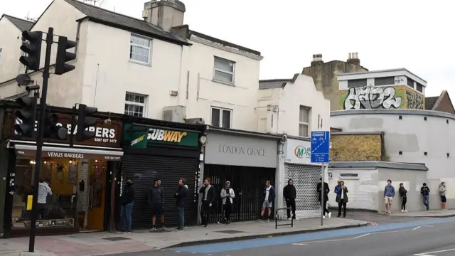 Members of the public queue outside a Barbers in Clapham on July 04, 2020 in London, United Kingdom. Hairdressing Salons reopen today having been closed for over three months in the UK due to the Coronavirus Pandemic.