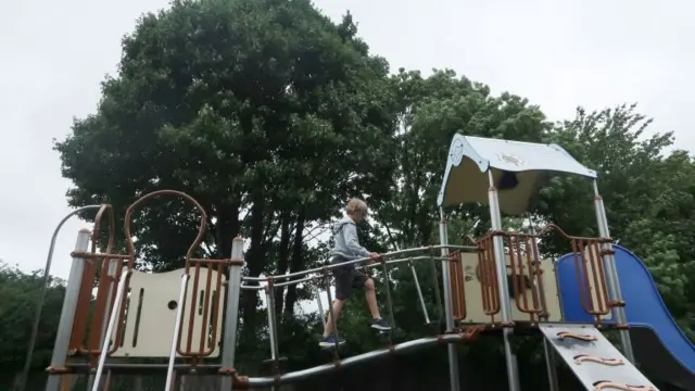 A child plays on a climbing frame at a playground in Wallington