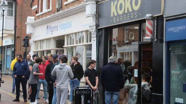 Men wait to enter a Barbers in Ashford, Kent, as coronavirus lockdown restrictions are eased across England