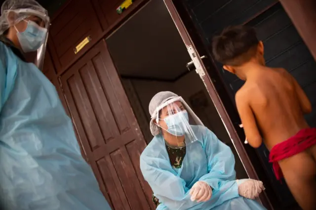 Health professionals talk to a Yanomami child amidst the coronavirus pandemic at the 4 Special Border Platoon on July 01, 2020 in Alto Alegre, Brazil.