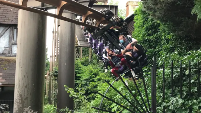 People wear face masks on one of the rides at Chessington