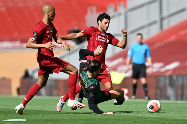 Jack Grealish (bottom) slides in to tackle Liverpool's English midfielder Alex Oxlade-Chamberlain