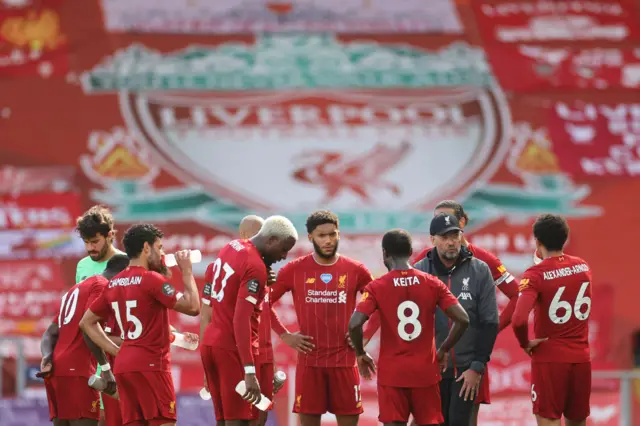 Jurgen Klopp speaks to his players on a drinks break