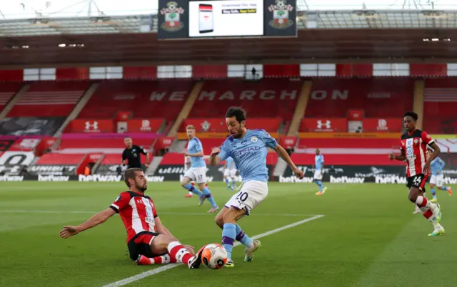 Bernardo Silva (C) vies for the ball against Jack Stephens