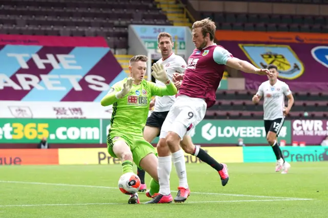 Chris Wood of Burnley is challenged by Dean Henderson of Sheffield United during the Premier League match between Burnley FC and Sheffield United