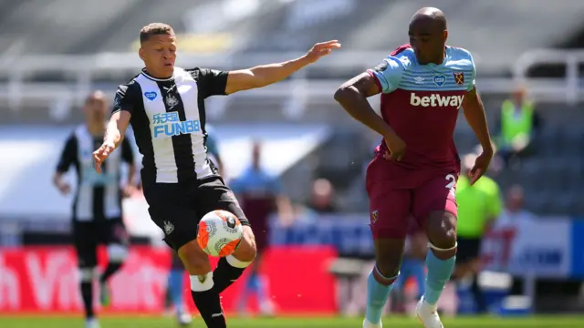 Dwight Gayle of Newcastle United is challenged by Angelo Ogbonna of West Ham United