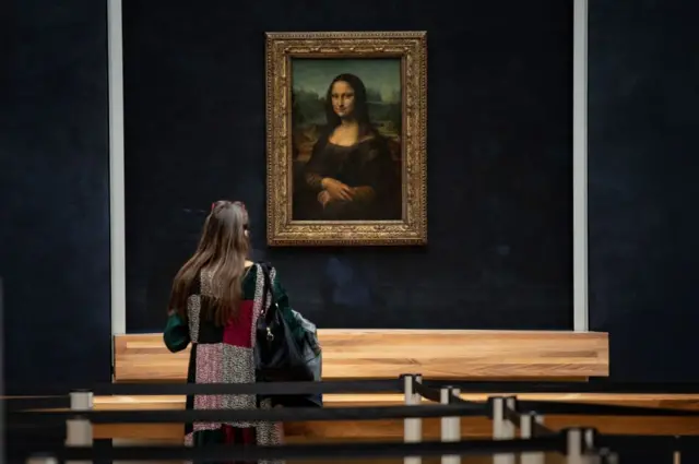 A woman in front of Italian artist Leonardo da Vinci's Mona Lisa