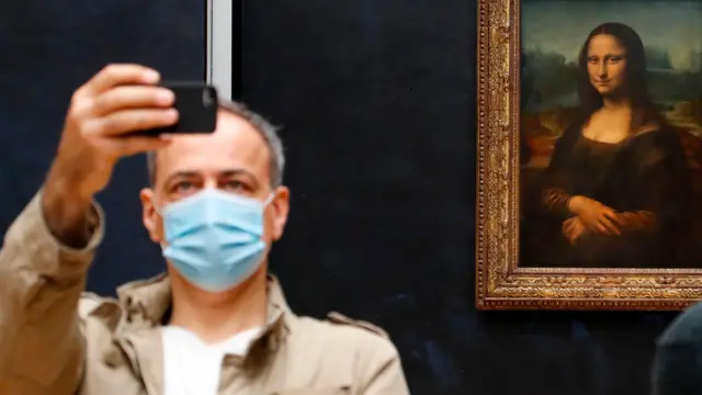 Man in mask visits the Louvre on the day of its reopening, and takes a selfie with the Mona Lisa