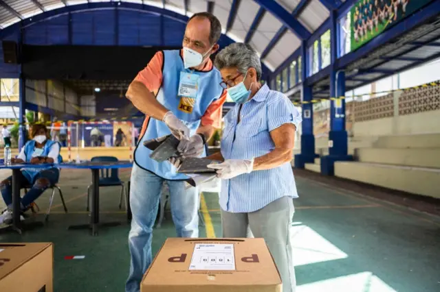 Two people help prepare a polling station for voting during the election in Santo Domingo, on July 5, 2020