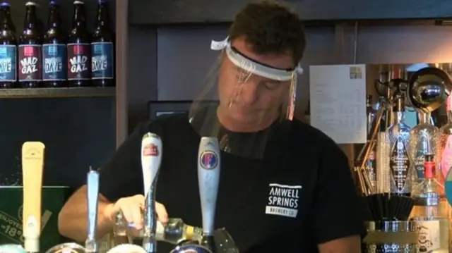 Landlord David Haines serving a pint