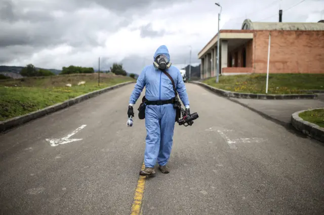 A cameramen wearing a protective suit is seen at the crematorium in Bogota, Colombia 6 July 2020