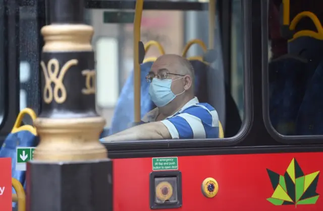 A man wears a face covering on a bus