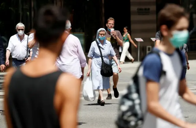 A woman wears a face mask in the street after Catalonia"s regional authorities decided to make mandatory the use of face masks in public at all times