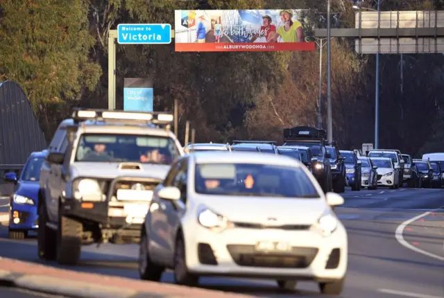 Essential travel is permitted for permit holders between the two states. This photo shows drivers at a checkpoint to enter New South Wales on Wednesday