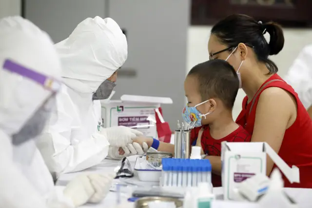 A child who has recently returned from Da Nang city has his blood tested at a makeshift rapid testing centre for coronavirus in Hanoi, Vietnam, 31 July 2020.