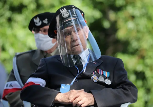 Veteran of the Warsaw Uprising Stanislaw Lipinski wearing a protective face shield attends a ceremony marking the upcoming 76th anniversary of Warsaw Uprising