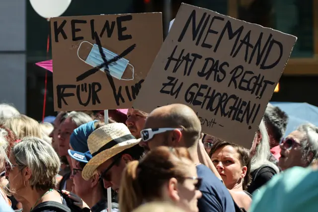 Demonstrators hold a banner reading "Nobody has the right to obey"