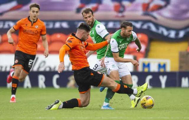 Martin Boyle of Hibs is tackled by United's Ryan Edwards