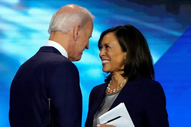 Former Vice President Joe Biden talks with Senator Kamala Harris after a Democratic debate