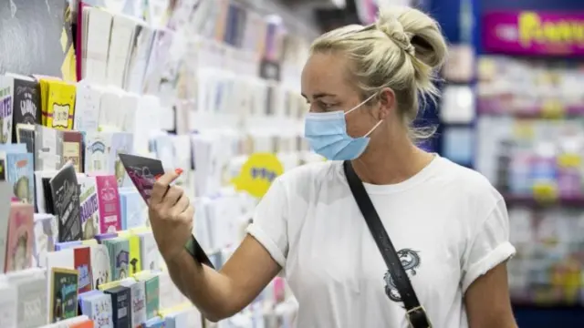 A woman browsing cards in a shop